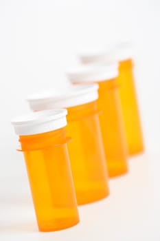 Yellow medicine bottles lined up in a row. Vertical shot. Isolated on white.