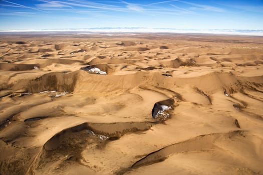 Aerial view of a desert landscape with sand dunes. Horizontal shot.