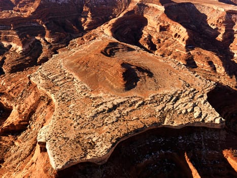 Aerial of a mesa and the surrounding canyon in a desert landscape. Horizontal shot.