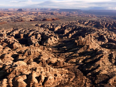 Rock formations caused by wind and water in the desert with a mesa in the background. Horizontal shot.