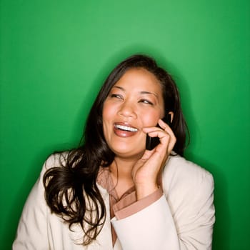 Portrait of pretty African American businesswoman smiling and talking on cellphone.