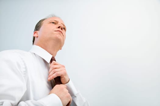 Caucasian middle aged businessman fixing necktie.