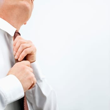 Caucasian middle aged businessman fixing necktie.