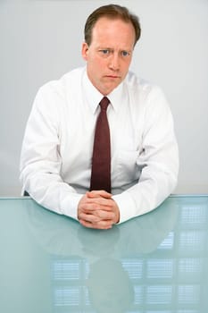 Portrait of Caucasian middle aged businessman sitting at desk.