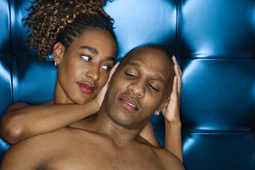 Attractive young shirtless couple sharing a tender moment. The woman is cradling the man's head in her hands. Horizontal shot.