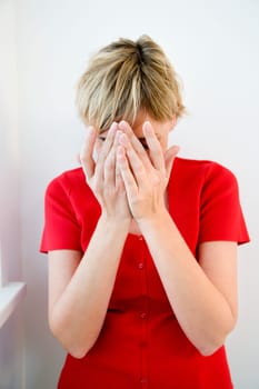 Woman holding hands over face.