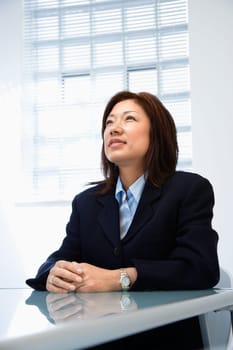 Portrait of Asian businesswoman sitting at desk.