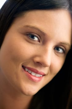 Close up of pretty young brunette Caucasian woman smiling.