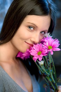 Portrait of pretty young Caucasian woman holding bouquet of flowers.