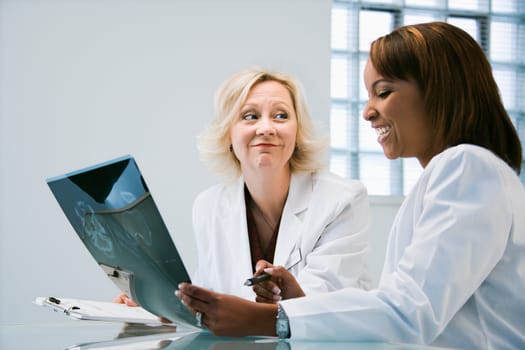 Women doctors looking at patient x ray films.