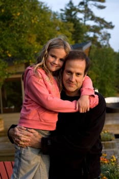 Father and daughter embracing outdoors, Lake of the Woods, Ontario, Canada
