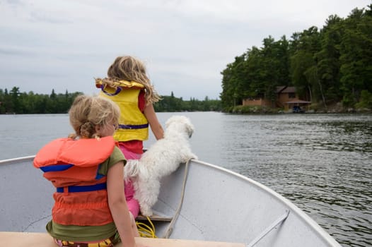 Children in boat with dog, Lake of the Woods, Ontario, Canada