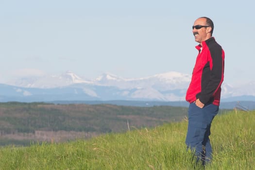 calgary, alberta, canada a male hiker overlooking the valley with mountains