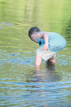 a young boy playing in the shallow water