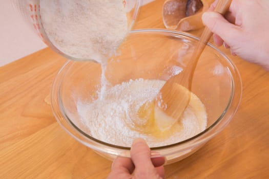 person mixing ingredients into a bowl