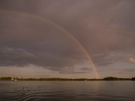 Rainbow over lake shoreline, Lake of the Woods, Ontario, Canada