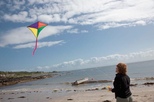 Woman flying a kite on the beach