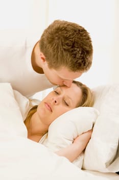 Loving husband caring for sick wife in bed