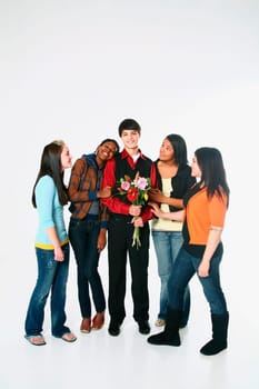 girls surrounding a boy who is holding flowers
