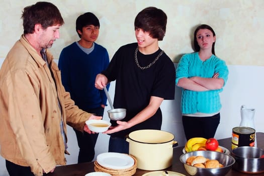 teenagers serving a meal to a man