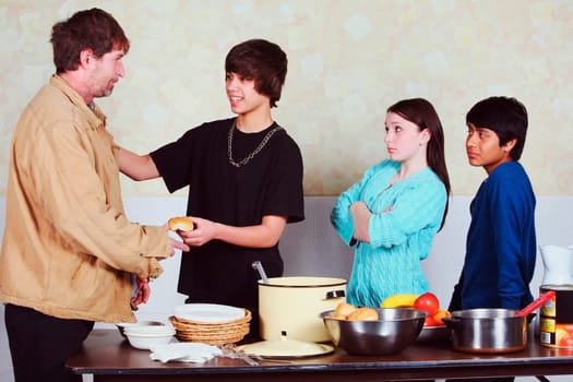 teenagers with differing attitudes serving a meal to a man