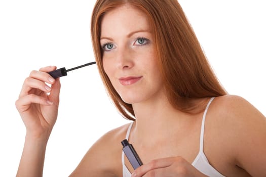 Body care - red hair woman apply mascara