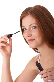 Body care - red hair woman apply mascara