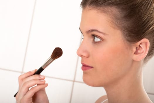 Body care - young woman apply powder
