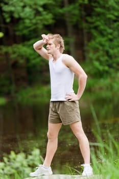 Sportive man stretching after training in nature