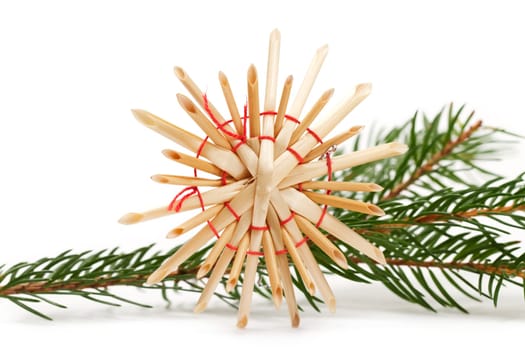 Straw star in front of fir branch