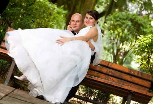 Bride and groom sitting on bench
