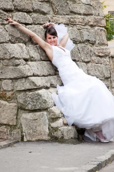 Bride  posing against old wall