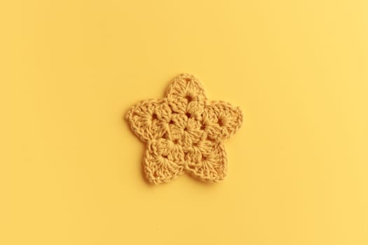 The yellow crocheted star on a yellow background
