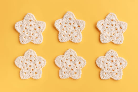 White crocheted stars pattern on a yellow background