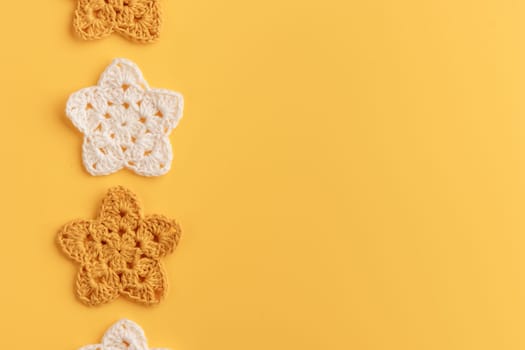 White and yellow crocheted stars row pattern on a yellow background