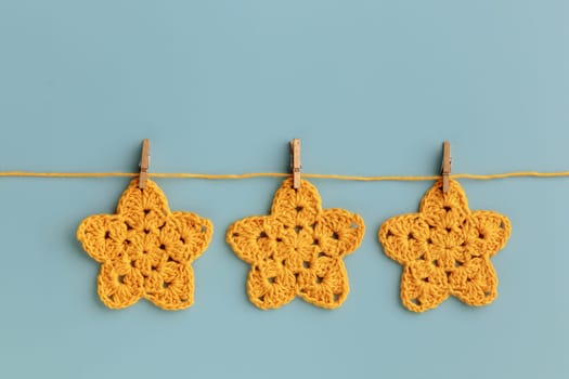 The  yellow  crocheted star on a bright background with copy space / pattern