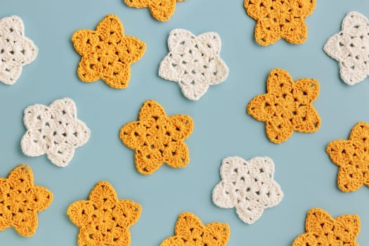 White and yellow crocheted stars pattern on a blue background