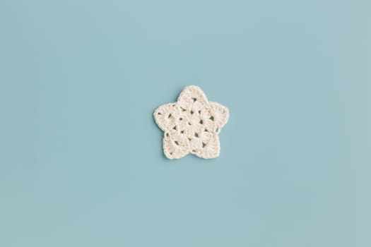 The white and yellow  crocheted star on a bright background with copy space / pattern