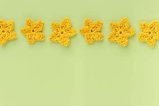 The yellow  crocheted star on a bright background with copy space / pattern