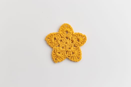 The yellow crocheted star pattern on a white background