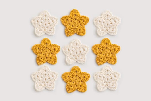 The white and yellow  crocheted star on a bright background with copy space / pattern