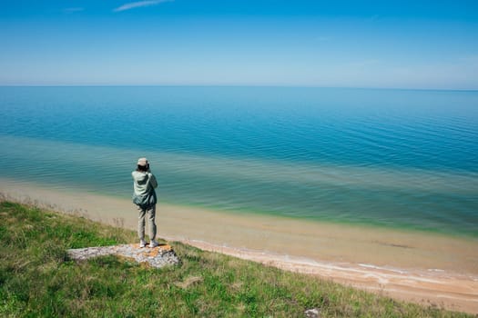 woman stands on a mountain and looks out over the sea nature travel hiking