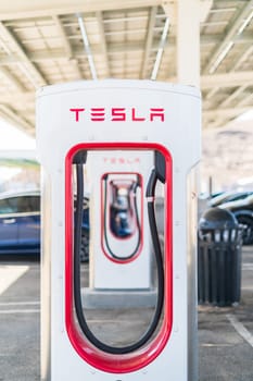 Baker, California, USA-October 12, 2021 - Tesla supercharging station during the day.