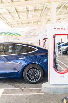 Baker, California, USA-October 12, 2021 - Tesla supercharging station during the day.