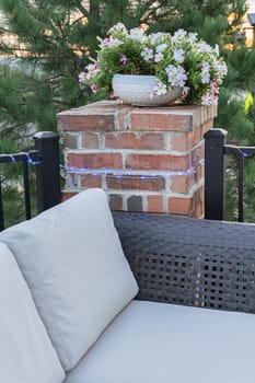 Morning on a summer day. Fully furnished backyard patio with a grill, sitting area, and umbrella.