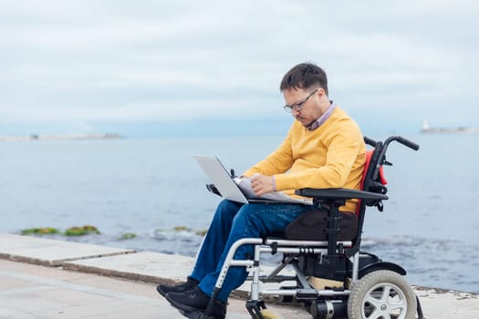 special person with disabilities with a laptop at sea