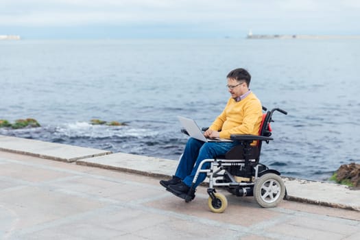 special person with disabilities with a laptop at sea