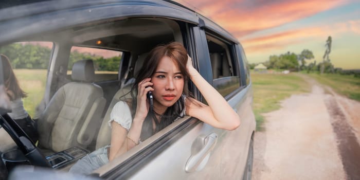 Yong women talking on a cell phone in a broken car concept travelling driving rest.