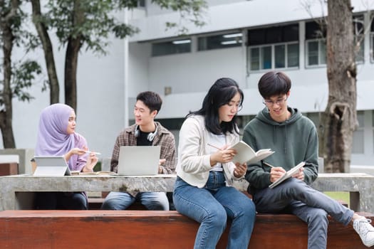 A multiracial group of students at the college, including Muslim and Asian students, sat on benches in a campus break area. Read books or study for exams together..