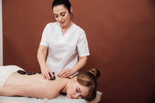 masseur performs massage with stones in the massage room